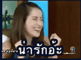 a woman is laughing in a foreign language while holding her hair .