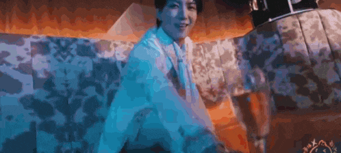 a man in a white shirt and tie is sitting on a couch in a room with a pyramid in the background .