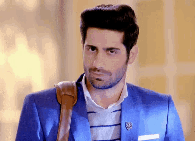 a man wearing a blue suit has a badge on his jacket that says ' a ' on it