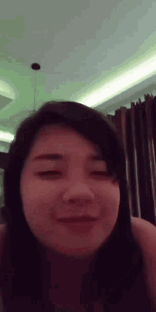 a close up of a woman 's face with her eyes closed and smiling .