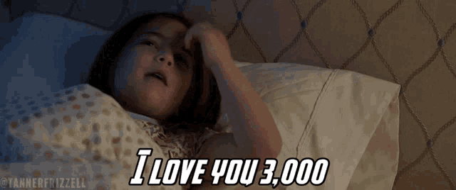 a little girl is laying in bed and says i love you 3000