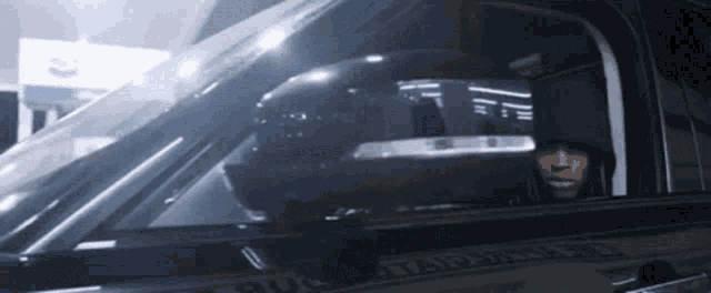 a man in a hooded sweatshirt is sitting in a car .