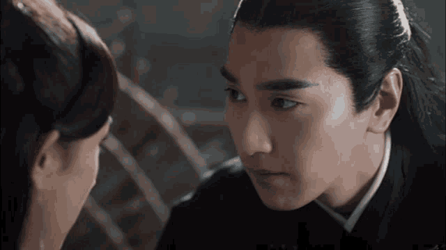 a man and a woman are looking at each other with a serious look on their faces