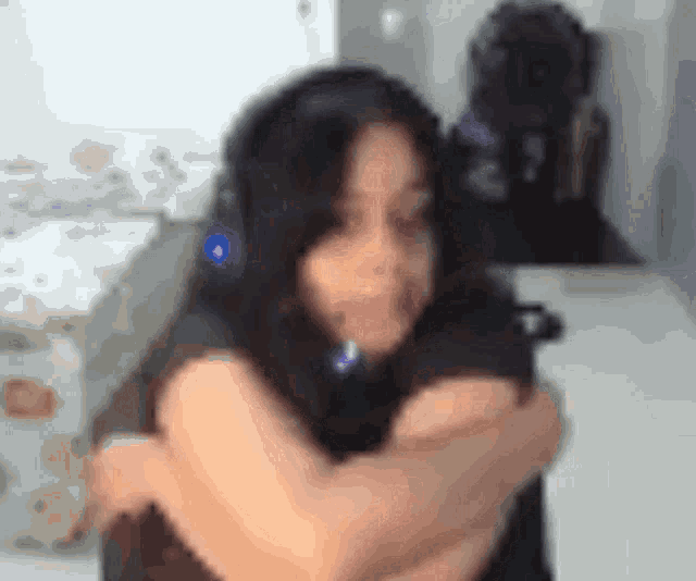 a blurry picture of a woman with her arms crossed .