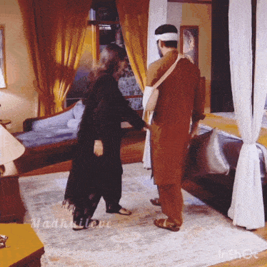 a man and a woman are standing in a room with the name madhuilove on the bottom right