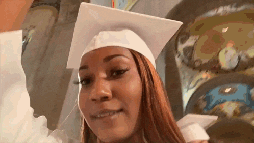 a woman wearing a graduation cap and gown is smiling