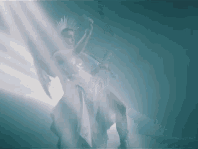 a woman in a white dress is dancing in the dark