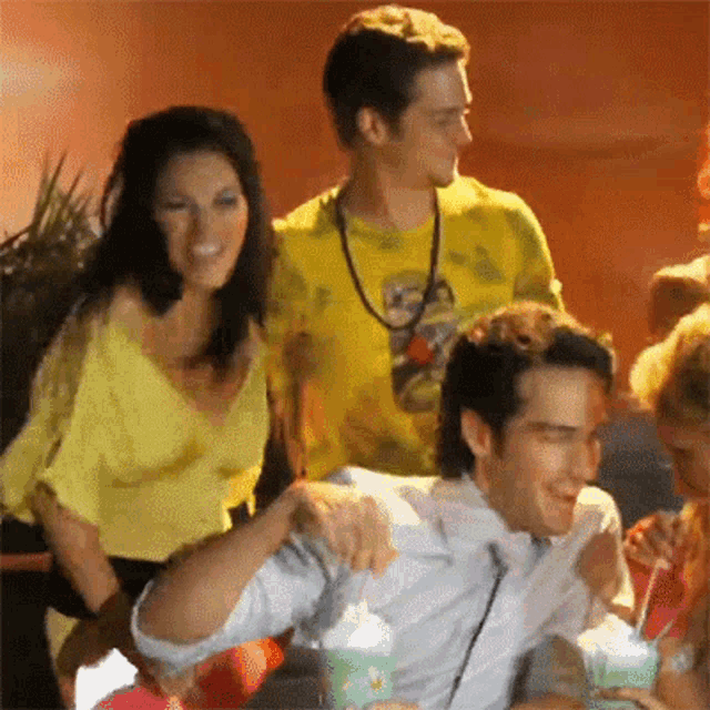 a man in a yellow shirt with a sloth on it stands next to a woman in a yellow top