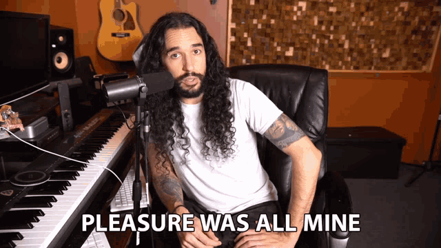 a man sitting in front of a microphone with the words pleasure was all mine behind him