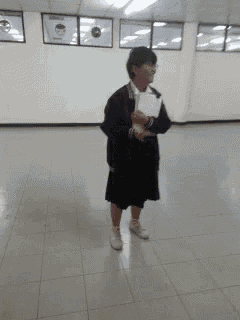 a woman standing in a room holding a piece of paper in her hand