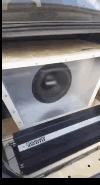 a subwoofer is sitting inside of a box with a subwoofer amplifier next to it