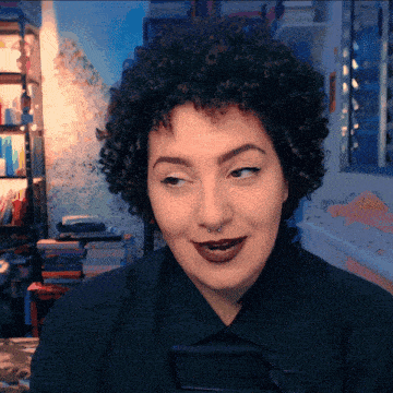 a woman with curly hair has a nose ring