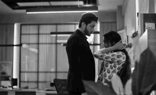 a man and a woman are standing next to each other in a room .