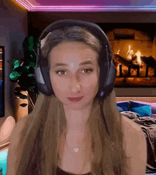 a woman wearing headphones is looking at the camera .