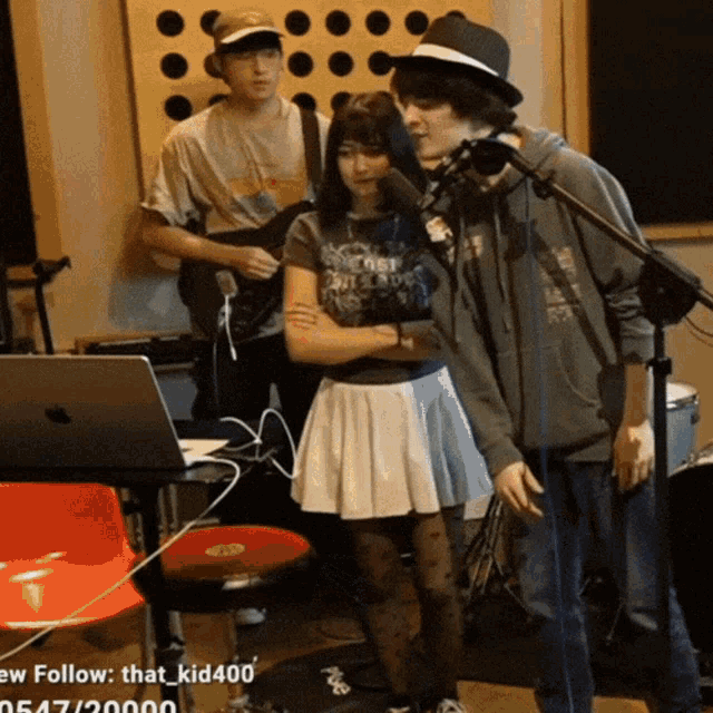 a group of people standing in front of a microphone with the hashtag that kid400
