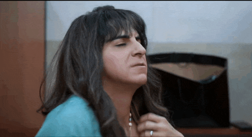 a woman with long hair is making a funny face with her eyes closed