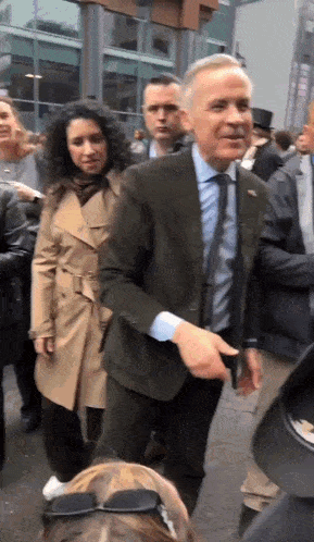 a man in a suit and tie is standing in a crowd of people