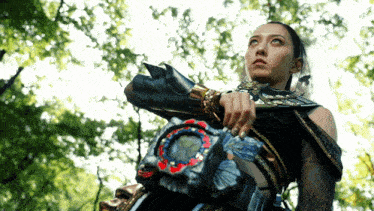 a woman in a costume is holding a sword in her hand