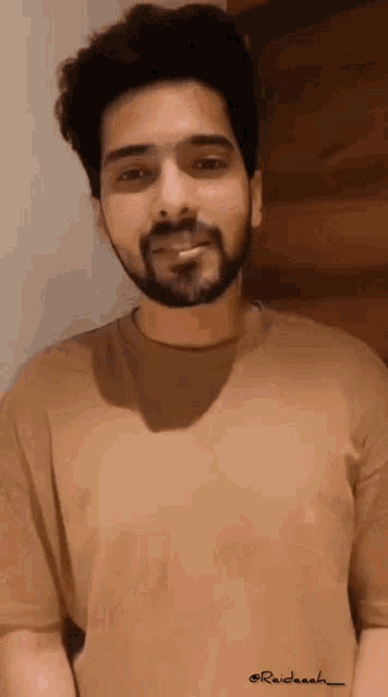 a man with a beard is wearing a t-shirt that says raidaash on it