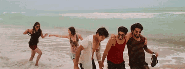 a group of people are walking on a beach