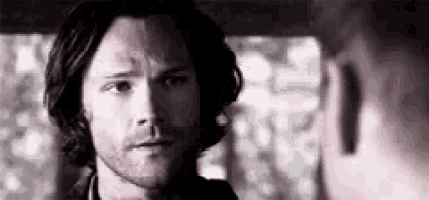 a man with a beard is looking at another man .