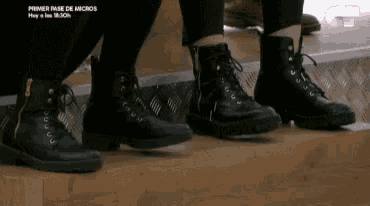 a person wearing a pair of black boots is standing on a set of stairs