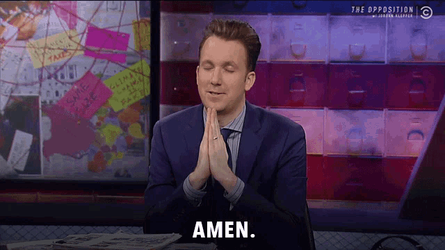 a man in a suit and tie is praying with the word amen on his face