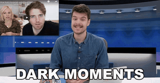 a man in a denim shirt stands in front of a screen that says dark moments