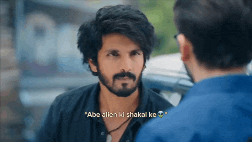 a man with a beard and mustache is talking to another man with a sticker that says abe alien ki shakal ke