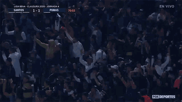 a crowd of people watching a soccer game with fox deportes on the bottom