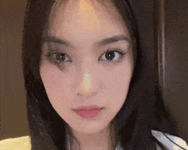 a close up of a young woman 's face with long black hair
