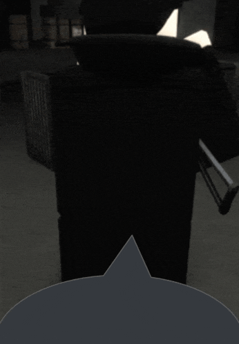a dark room with a black chair and a gray speech bubble