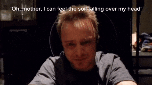 a man sits in a messy room with the words " oh mother i can feel the soil falling over my head " above him