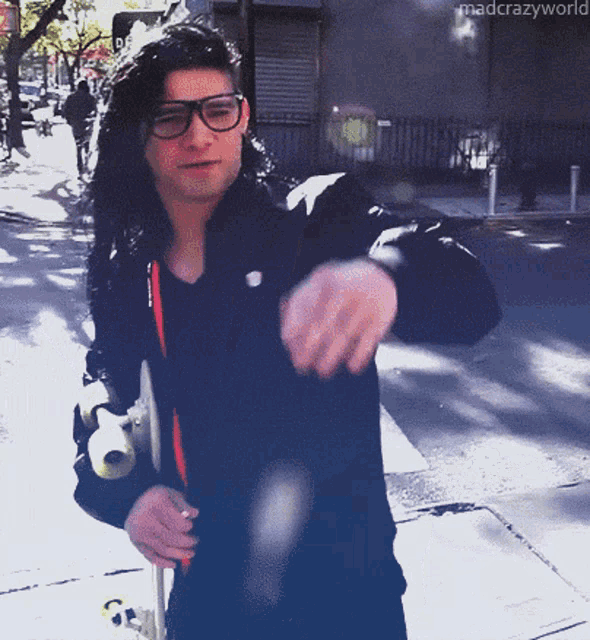 a man wearing glasses and a black jacket is walking down a street with the words mad crazy world written on the bottom