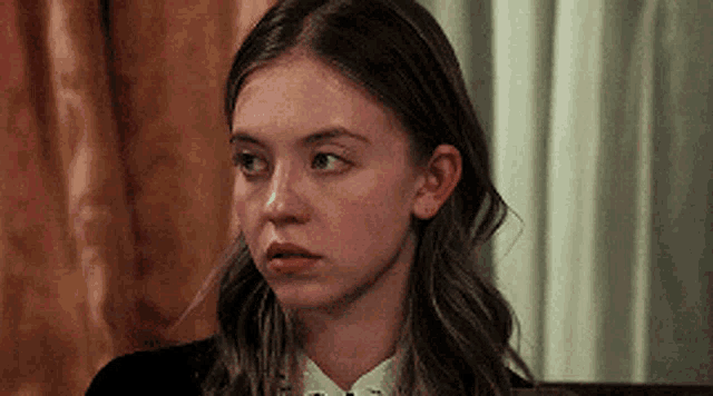 a close up of a woman 's face with a serious expression on her face .