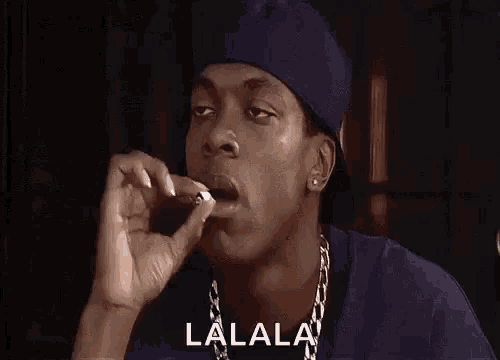 a man in a hat is smoking a cigarette .