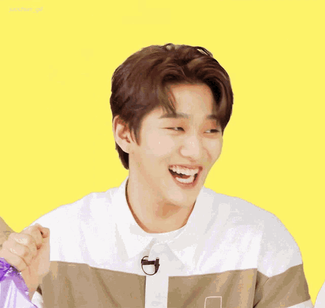 a young man with a pantone logo on his shirt is laughing with his mouth open