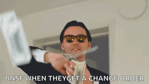 a man wearing sunglasses is holding a bunch of money in his hands .