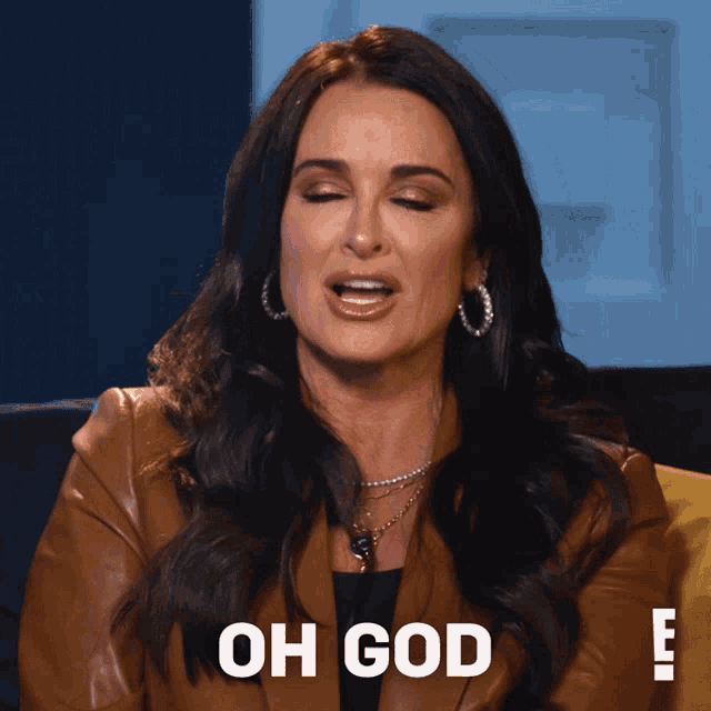 a woman in a brown jacket says oh god in front of her face