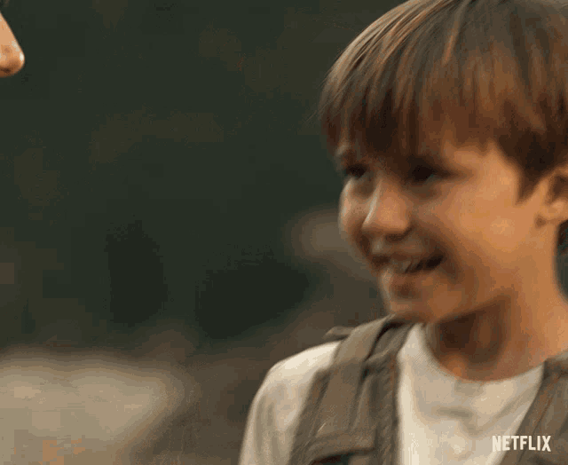 a young boy is smiling with a netflix logo in the corner