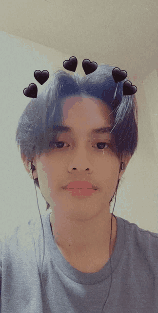 a young man wearing ear buds and hearts on his hair