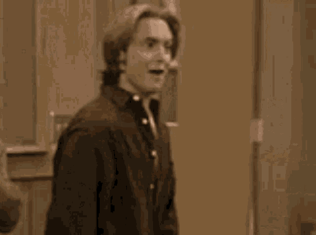 a man is standing in front of a door with his mouth open .