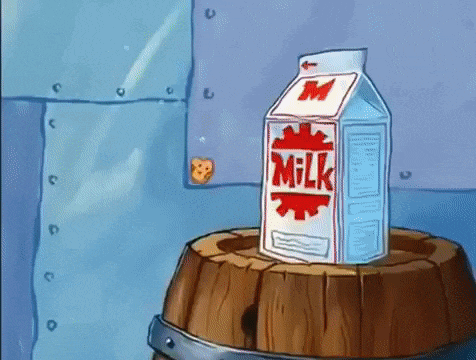a carton of milk sitting on top of a wooden barrel .