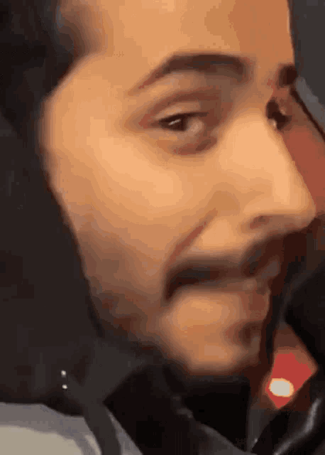 a close up of a man 's face with a beard making a face .