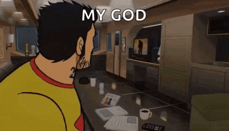 a man in a yellow shirt is sitting at a table in a living room looking at a tv .