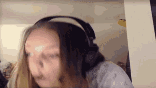 a woman wearing headphones is making a funny face .