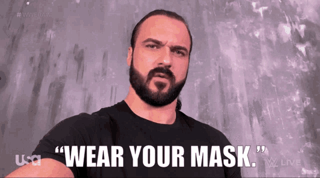 a man with a beard is wearing a black shirt that says wear your mask