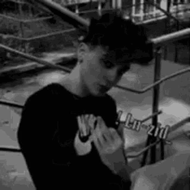 a black and white photo of a young man wearing a black nike shirt .