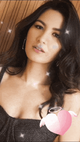 a woman in a black top with a pink heart on her chest