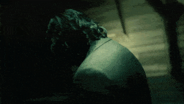a man with long hair is looking down at something